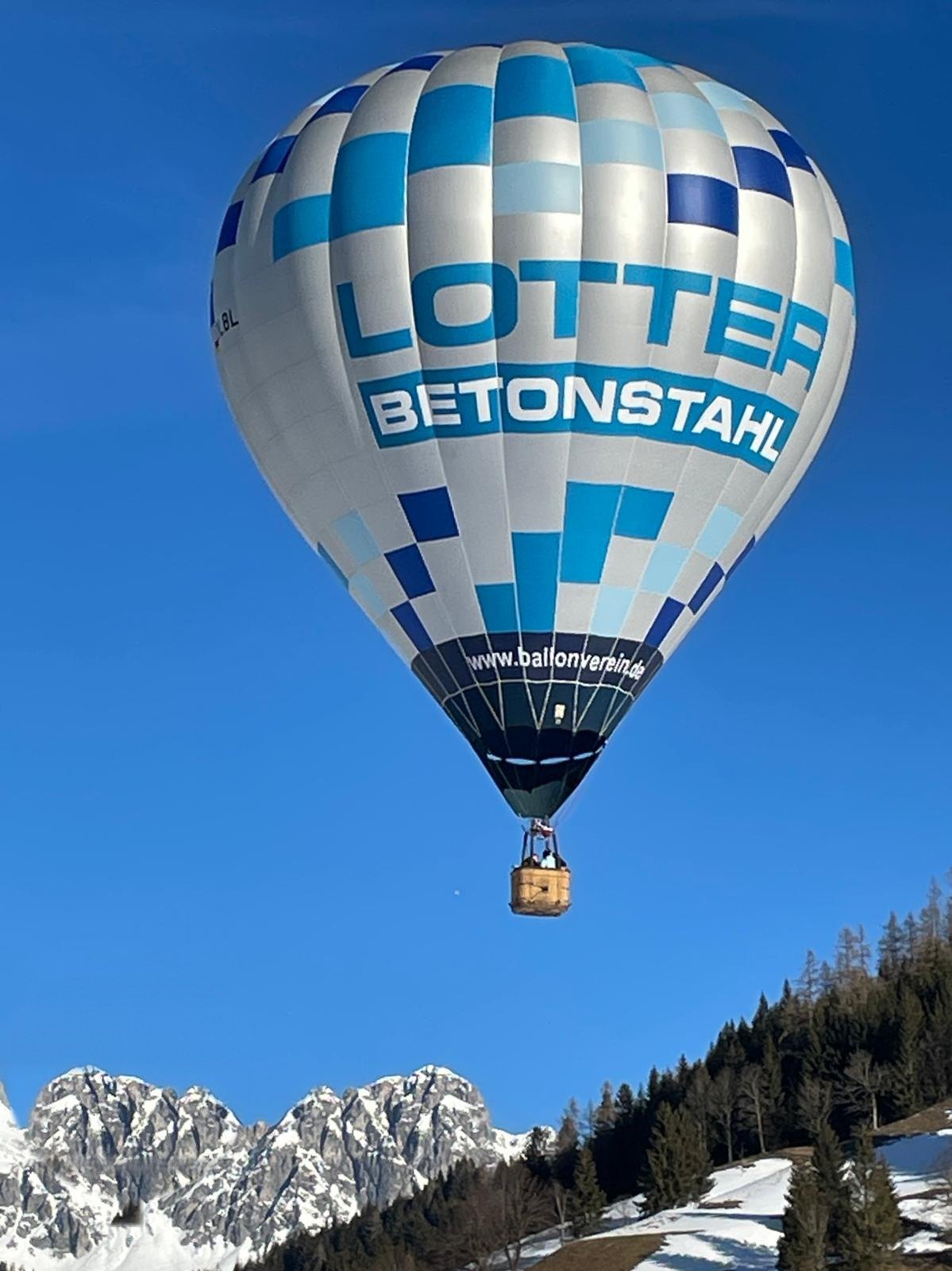 Der Vereinsballon in der Luft über den Alpen, der Schriftzug LOTTER Betonstahl gut lesbar auf der Hülle